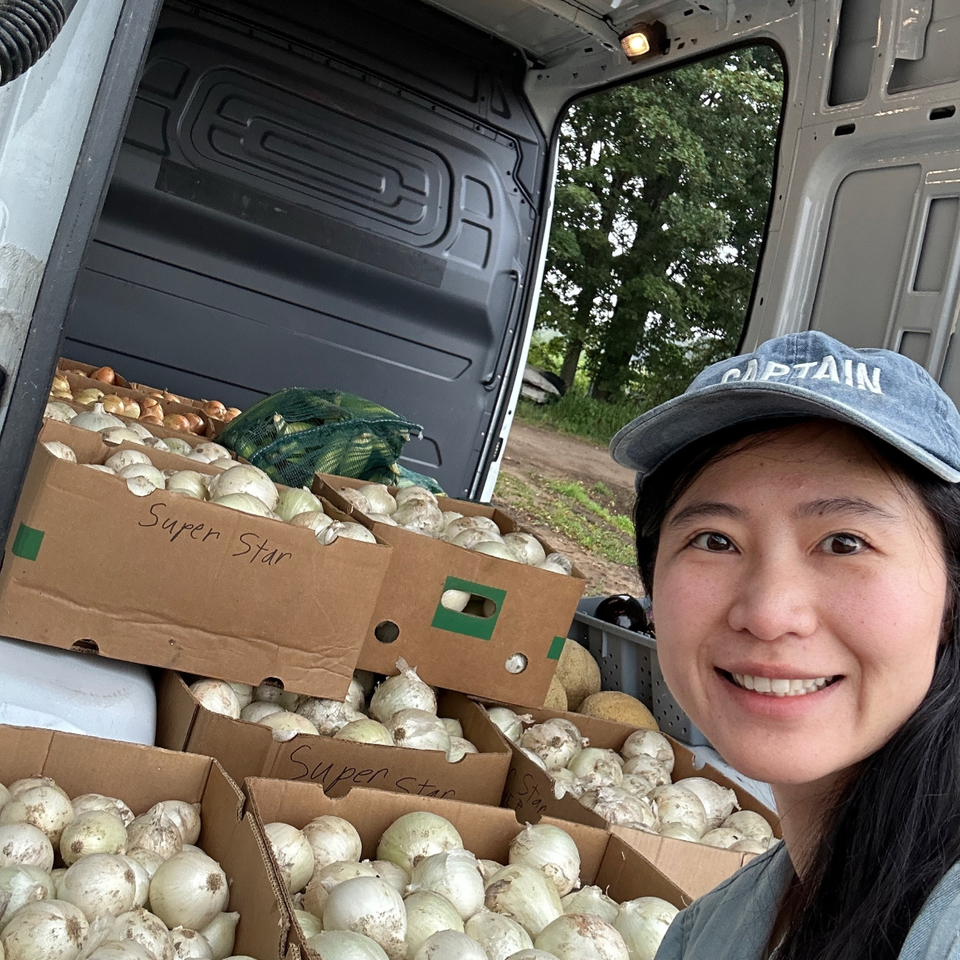 A smiling member of the Nature’s team with boxes of fresh produce in a delivery van